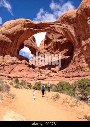 Hikers at Double Arch, Arches NP, Utah Stock Photo