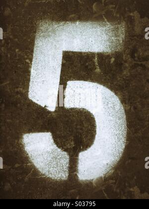Number five spray painted in white using a stencil Stock Photo