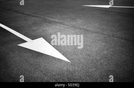 Painted opposite white arrow sign on asphalt Stock Photo