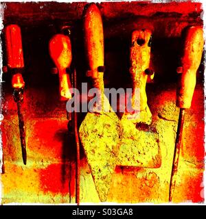 Line of dirty paint splattered old tools in a shed Stock Photo