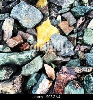 Different coloured rocks and pebbles on the shore. Stock Photo