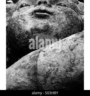 Face of a child on old stone statue Stock Photo