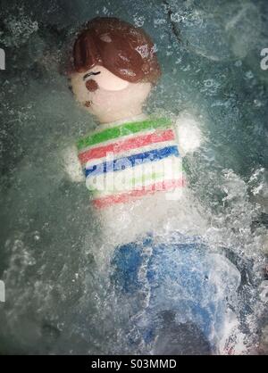 Playmobil on ice. Frozen woman toy after a shipwreck. Stock Photo