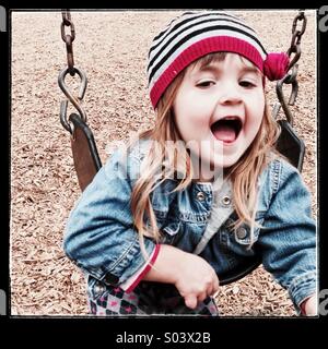Toddler Caucasian girl having fun on a swing Stock Photo