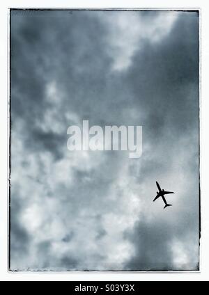 Commercial jet in cloudy sky Stock Photo