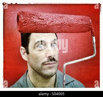 Painter with red paint roller Stock Photo