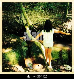 Girl balancing on fallen tree Stock Photo