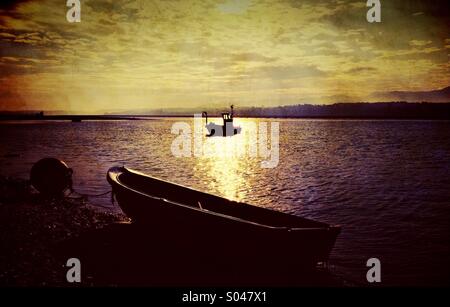Moored boat at low tide on Menai strait on Anglesey Stock Photo