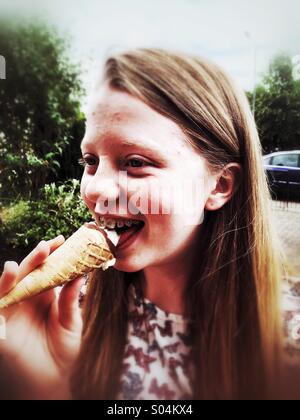 A teenage girl eating an ice cream cone Stock Photo
