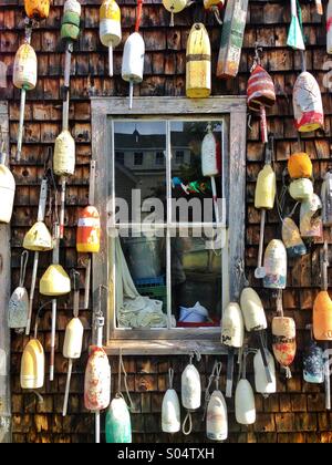 Old lobster buoys on building in Maine, USA. Stock Photo