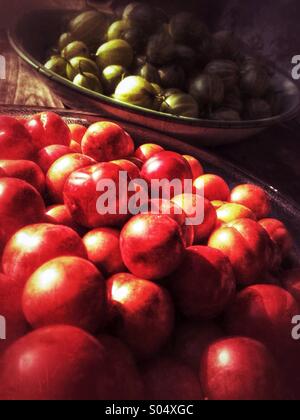 Plate of Cherries in front of a bowl of gooseberries Stock Photo