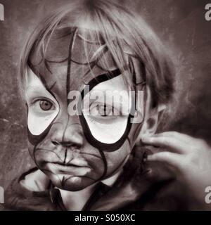 Sad Spidey. Boy unhappy in Spider-Man face makeup Stock Photo