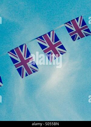 union jack flag flying against a blue sky with kites flying behind ...