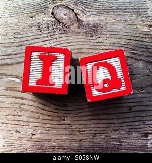 It's a photo of two wood cubes toy with letters that form the word IQ Stock Photo
