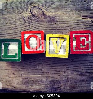 It's a photo of two wood cubes toy with letters that form the word LOVE Stock Photo