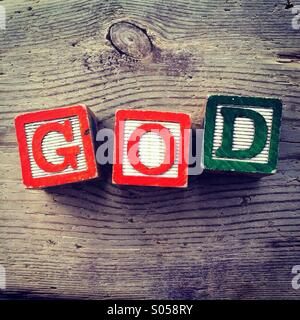 It's a photo of two wood cubes toy with letters that form the word GOD Stock Photo