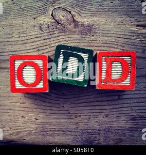 It's a photo of two wood cubes toy with letters that form the word ODD Stock Photo