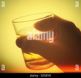 Hand holding glass of drink. Stock Photo