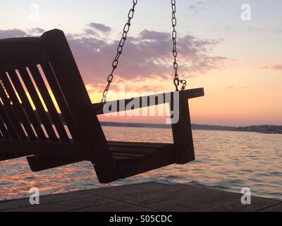 Sunset bench swing on lake Stock Photo