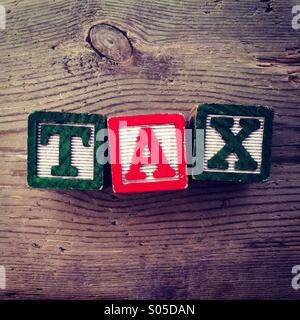 It's a photo of few wood blocks toys with alphabet letters on them combined together to create the word TAX Stock Photo