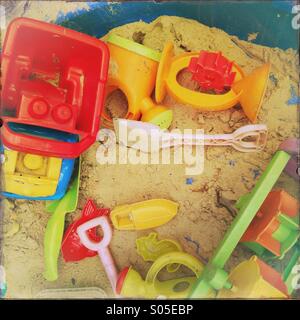 An arrangement of children's toys in a sandpit Stock Photo