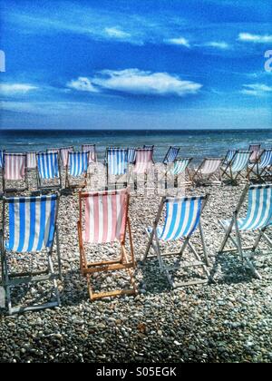 Empty deck chairs on a beach in the UK. Stock Photo