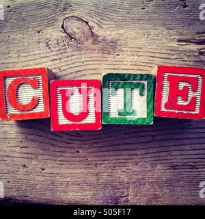 It's a photo of few wood blocks with letter on them that are combined together to create the word CUTE Stock Photo