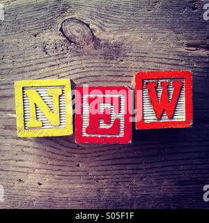 It's a photo of few wood blocks with letter on them that are combined together to create the word NEW Stock Photo