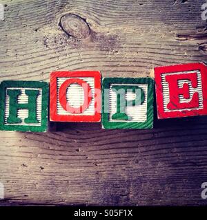 It's a photo of few wood blocks with letter on them that are combined together to create the word HOPE Stock Photo