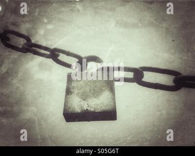 Old padlock and chain with grunge effect applied. Stock Photo