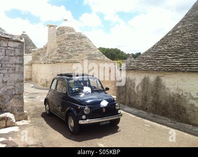 Mini wedding: a Fiat 500 becomes the wedding car of choice for a couple of newly-weds in Alberobello, a UNESCO World Heritage Site, in the province of Bari, Puglia, Italy Stock Photo