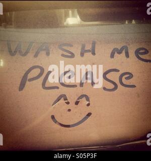 Wash me please written into dirt on a car window Stock Photo