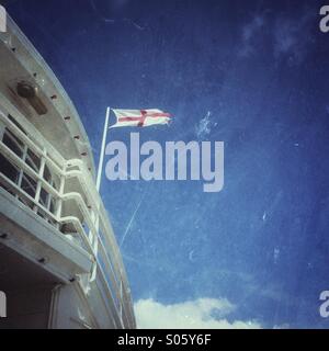 At George's cross flag flying against a blue sky from a building on brighton pier on a summers day Stock Photo