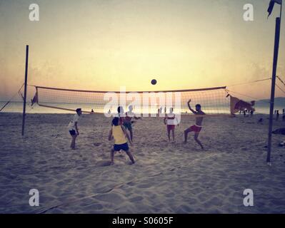 People on the beach playing volley ball at sunset. Stock Photo