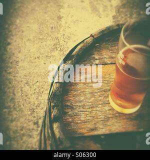 Beer glass on old wooden barrel Stock Photo