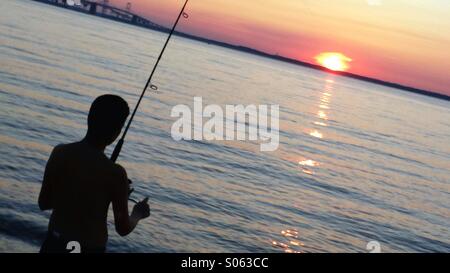 Fishing at Terrapin Park Beach as the sun sets over the Chesapeake Bay Bridge, August 2014. Stock Photo