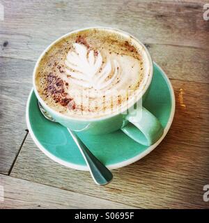 A cup of coffee/latte with picture of a leaf in the foam. Stock Photo