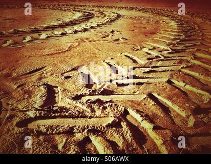 Curving tractor tracks in sand Stock Photo