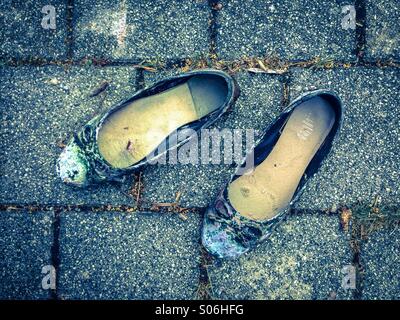 Old shoes on sidewalk Stock Photo