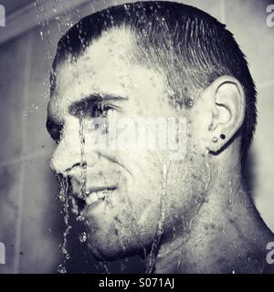Happy guy in shower cooling down Stock Photo
