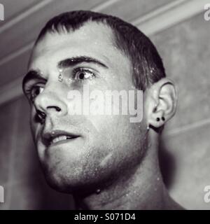 Man with wet face in shower Stock Photo