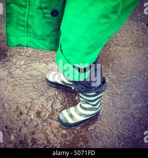 Boy standing in a Puddle Stock Photo