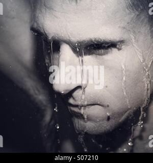 Moody image of man in shower Stock Photo