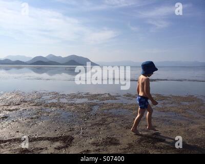 Toddler walking on wet sand Stock Photo