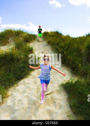 Two five year old children playing in sand dunes Stock Photo