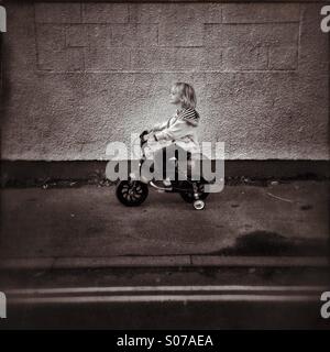 Kid on a bike with stabilisers Stock Photo