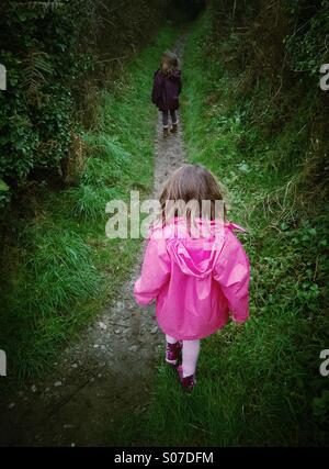 Two young girls walking along a countryside footpath. Stock Photo