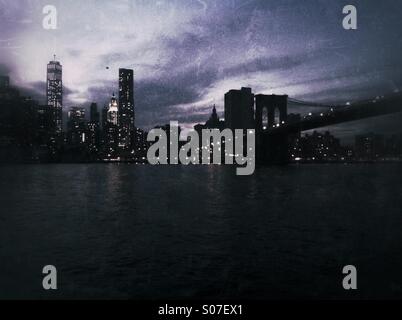 Night shot of New York City skyline including Brooklyn Bridge. Grunge style