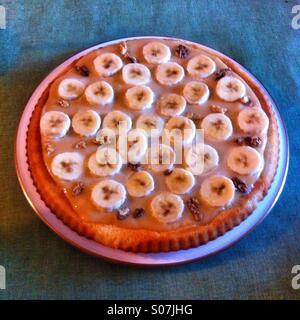 Banoffee pie -Delicious homemade banana tart with a golden crust and a rich filling served on a simple blue table Stock Photo