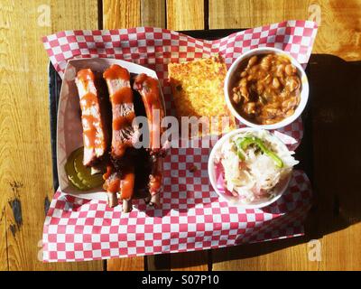 Southern barbecue ribs with baked beans, coleslaw and cornbread, at Moe's Original BBQ in Panama City Beach, Florida, USA. Stock Photo